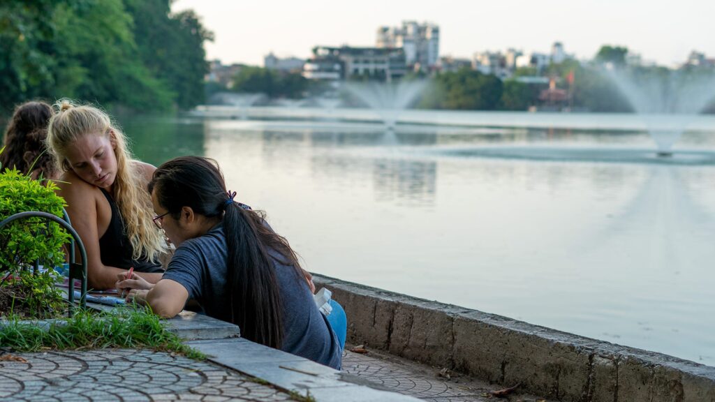 a local and a foreigner conversing by the lake
