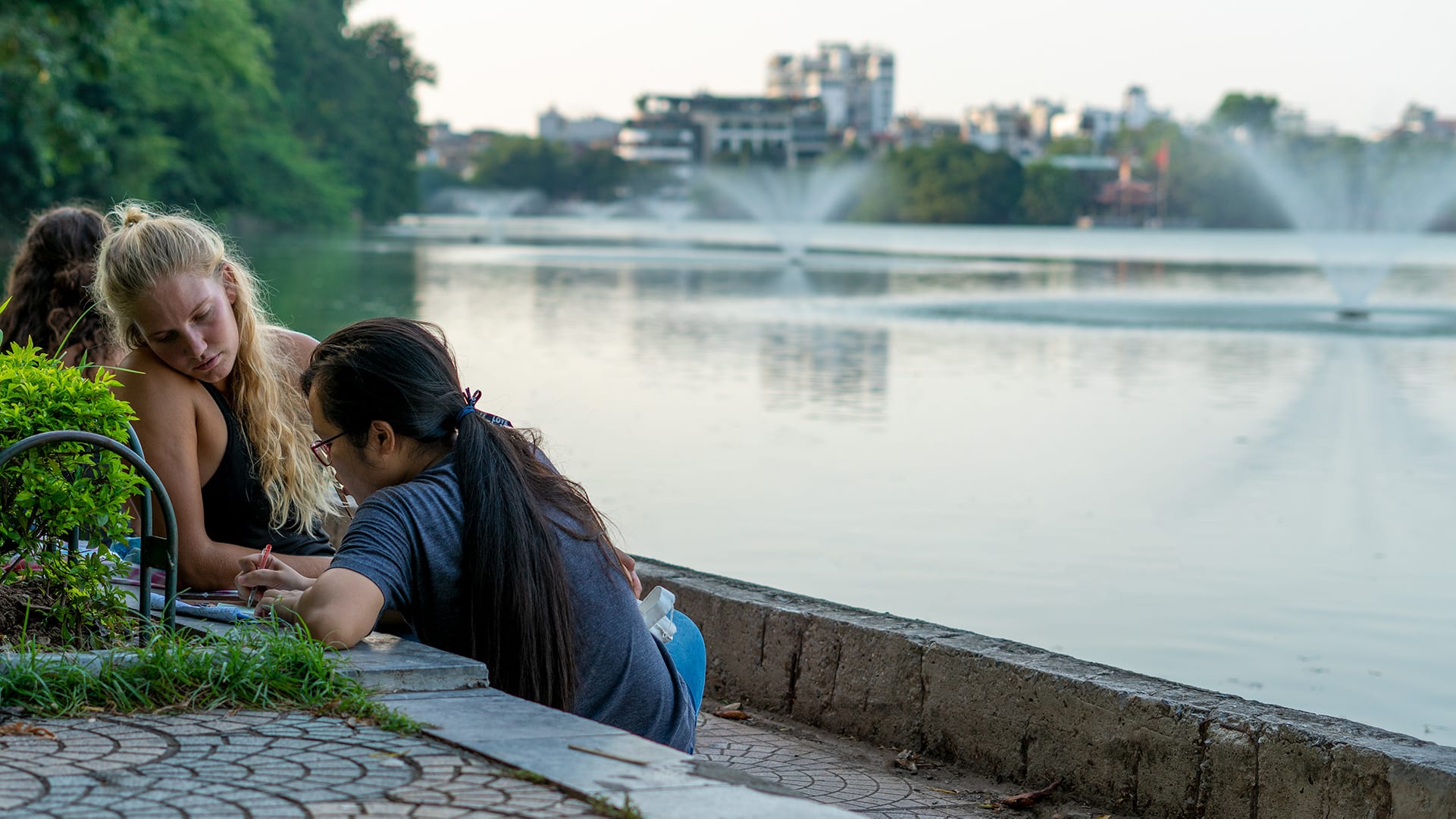 a local and a foreigner conversing by the lake
