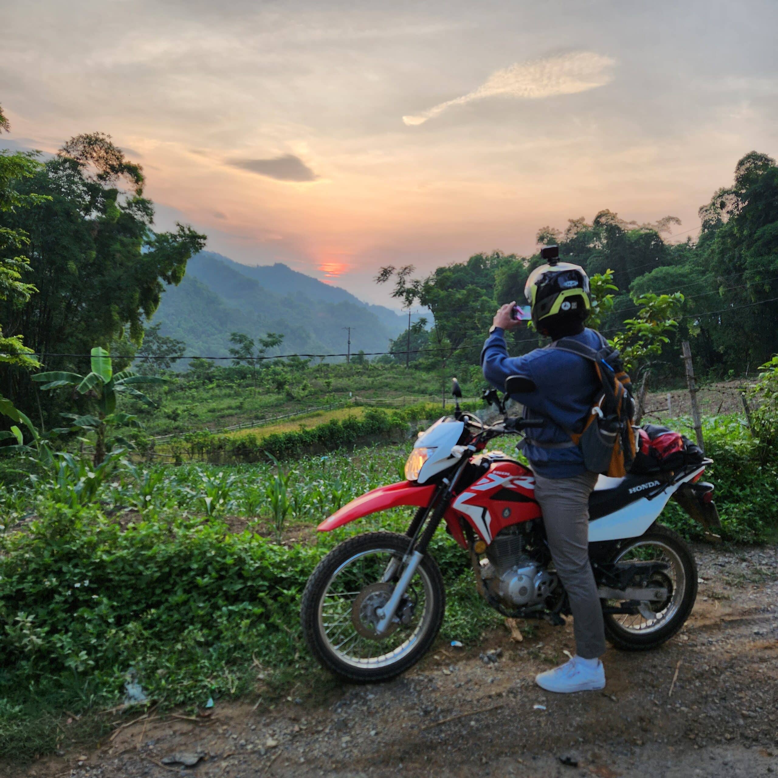 stopping to take a picture of the sunset over Da Bac, in Hoa Binh Province
