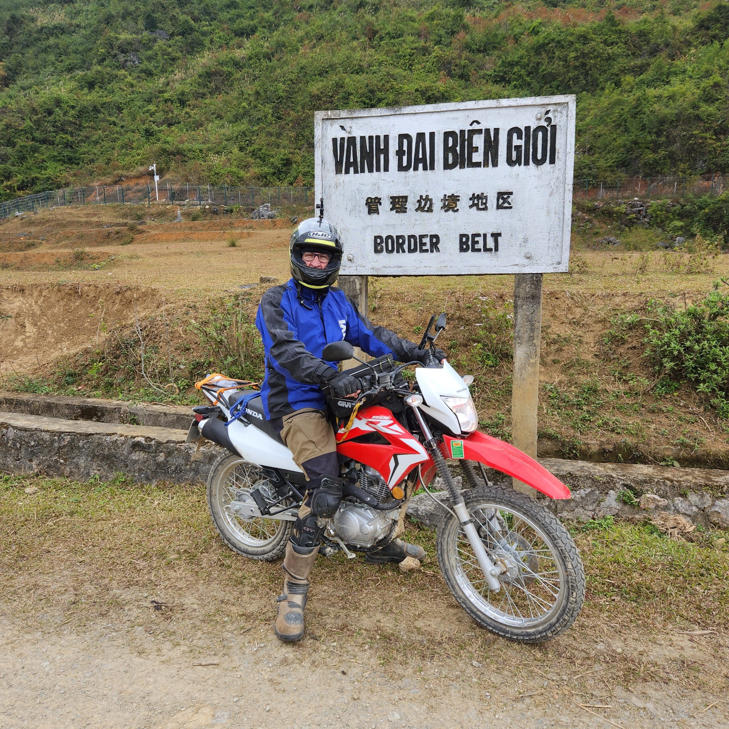 Honda XR150 at the border with the fence and china in the background