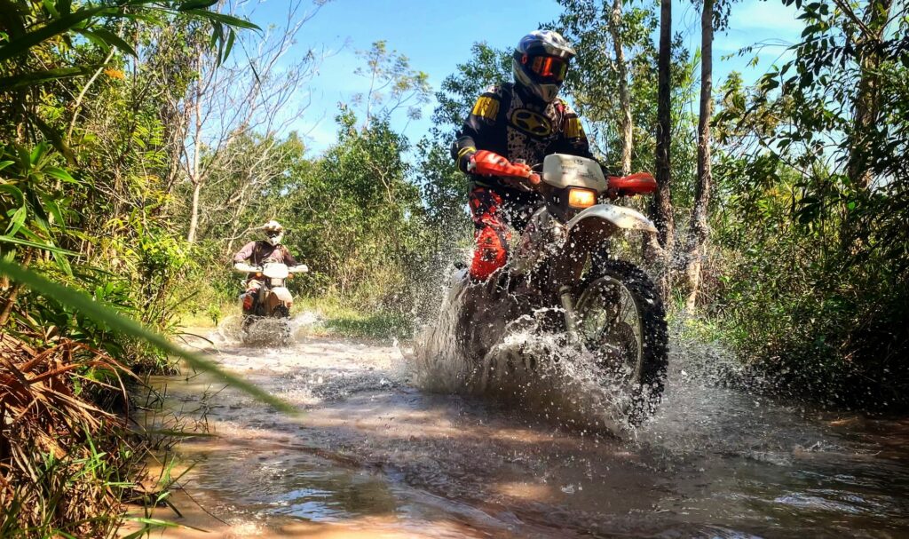 Vietnam motorcycle tour member crossing a small stream in the jungle