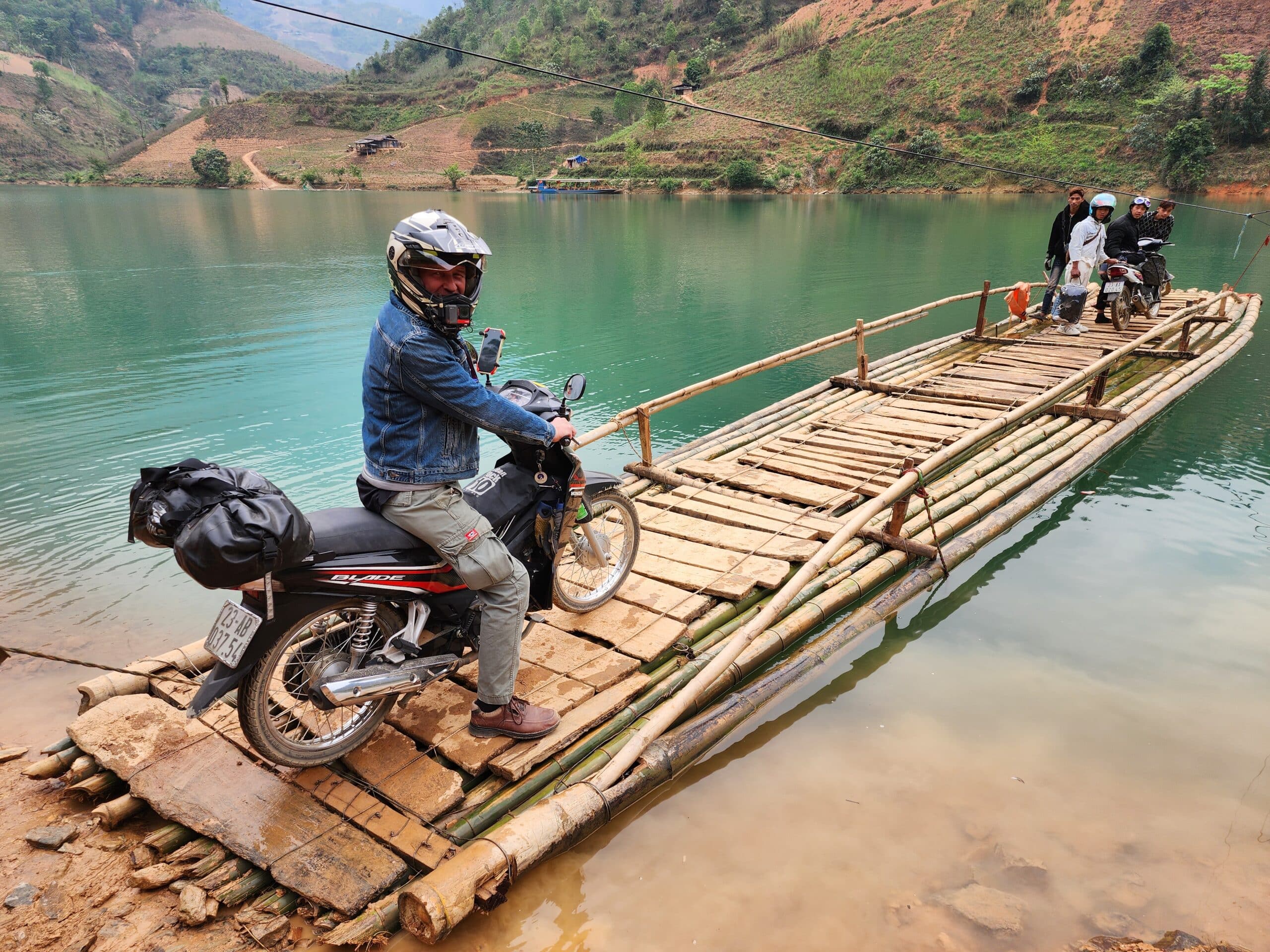 rider on a honda blade crossing the Nho Que river from Ha Giang to Cao Bang province.